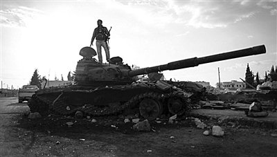 9月8日，敘利亞Zabadani，一名敘利亞反對派武裝人員站在廢棄的政府軍坦克上。