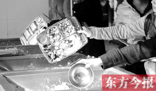 11月27日，河南中醫(yī)學(xué)院餐廳，一名同學(xué)將餐盤內(nèi)沒吃完的食物倒入餐具回收車內(nèi)