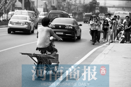 剛駛出隧道口，騎電動(dòng)車的他被交警攔下 邱曉峰/攝