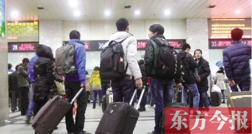 鄭州火車站東廣場(chǎng)售票大廳，幾名學(xué)生在售票窗口前躊躇