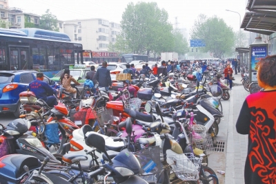 省人民醫(yī)院北門，路邊的公交站牌處停滿非機(jī)動車，上、下客只能在快車道上。