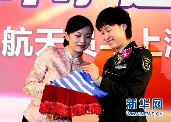 11月1日，航天員劉洋（右）在為“愛心”毛衣編織最后的收尾針。