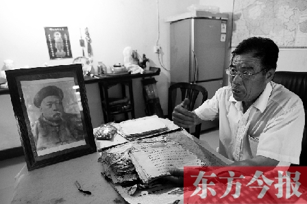 　魏樹紹手拿《物權(quán)法講義》手稿，在講訴先祖書寫“物權(quán)法”的歷史（相框里就是魏聯(lián)奎）