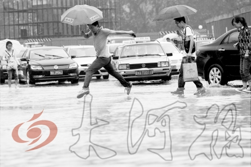 鄭州經(jīng)三路與北環(huán)交叉口處，積水較深，行人們不得不“練輕功”。 記者 白周峰 攝影