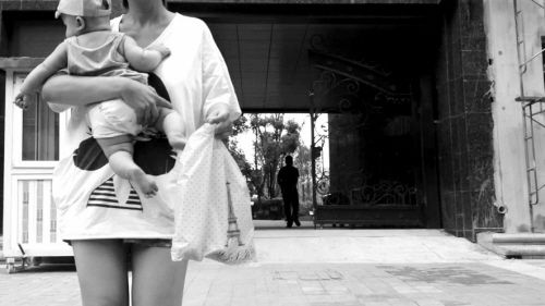 抱著孩子出售人奶的女子。