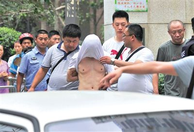 昨日，成都警方抓捕時與毒犯發(fā)生槍戰(zhàn)。一名男犯罪嫌疑人被警方押出。