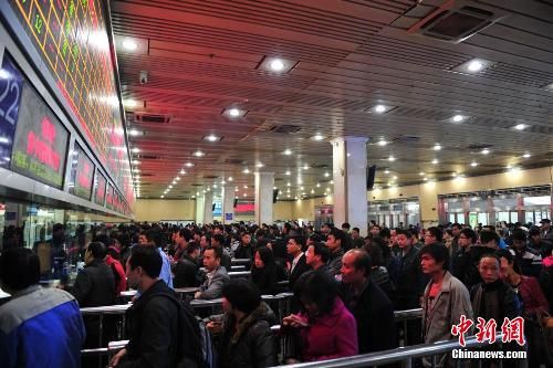 資料圖：12月25日，2014春運(yùn)臨客車票在廣州火車站開售，購(gòu)票市民在售票窗口前排起長(zhǎng)隊(duì)。中新社發(fā) 陳驥旻 攝