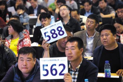 昨日，拍賣現(xiàn)場競拍者舉牌競拍。新京報記者