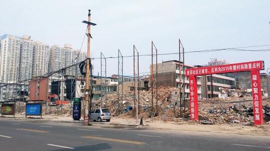 015年5月31日，在社區(qū)干部的帶頭拆遷下，親賢社區(qū)的“城中村改造”拉開帷幕。由于前期“清產(chǎn)核資”及補(bǔ)償標(biāo)準(zhǔn)等因素，拆遷改造工作推進(jìn)并不順利。圖為位于體育西路東側(cè)集體所有的商鋪率先被拆遷完畢，用于遮擋的圍擋正在施工中。（拍攝：2015年9月16日）