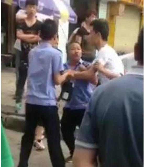 付某（右）與城管執(zhí)法人員廝打在一起。