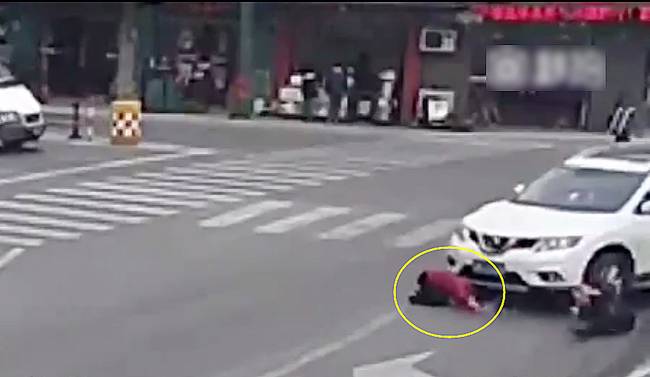 圖為小姑娘被卷進(jìn)車輪下瞬間。