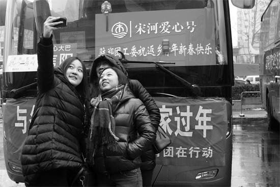 昨天上午8時(shí)，鄭州正道中環(huán)百貨廣場(chǎng)，準(zhǔn)備回家的老鄉(xiāng)在愛(ài)心大巴車前合影留念