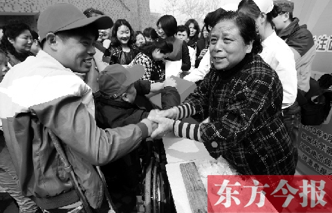 昨日，鄭大四附院的大樓前，“面人鄭”鄭玉芬（右）向前來(lái)捐款的殘疾人表示感謝