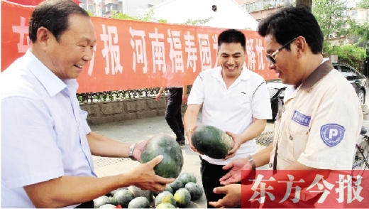 河南福壽園區(qū)域總經理吳正宗（左一）、東方今報發(fā)行中心副總監(jiān)王路喜（中）在街頭給市民送瓜