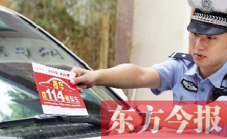 交警將“挪車請撥打114轉(zhuǎn)車主”的提示牌放在路邊?？康能嚿? width=