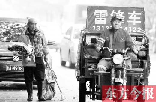 鄭州市商城路，一名環(huán)衛(wèi)工懷抱著剛剛收到的毯子，目送“雷鋒哥”孫德坤離開