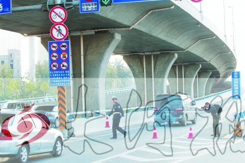 交警在東風(fēng)路從北向南上橋口處擺上反光錐，間歇放行