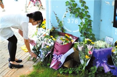 6月8日下午，記者來到廈門公交車爆炸事發(fā)現(xiàn)場橋下，附近已聚集了十幾個自發(fā)前來悼念的市民。橋墩下排放了一圈或黃或白的菊花，還有玖瑰、百合等。