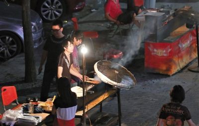 7月4日，青年路國美第一城小區(qū)附近的夜市臨街露天燒烤攤。