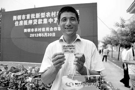 領(lǐng)到貸款，農(nóng)民開心地笑了。
