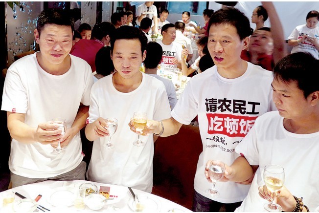 活動發(fā)起人張楠（右二）給農(nóng)民工敬酒。