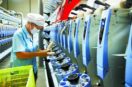 7月3日，在鄧州市永泰棉紡有限公司電腦控制全自動(dòng)紡紗車間，紡織工人正在生產(chǎn)棉紗。