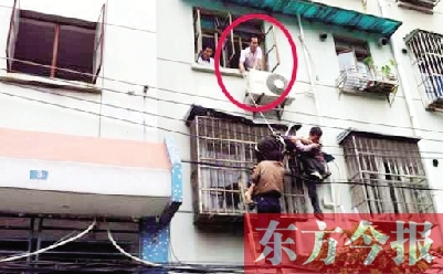 施救現(xiàn)場，劉鵬（圈內(nèi)）先用繩子捆住老太確保安全 勞動報記者 郭娜 供圖