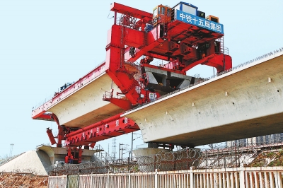 建設(shè)者們操縱巨型起重機(jī)在吊放橋墩。記者鄧放攝