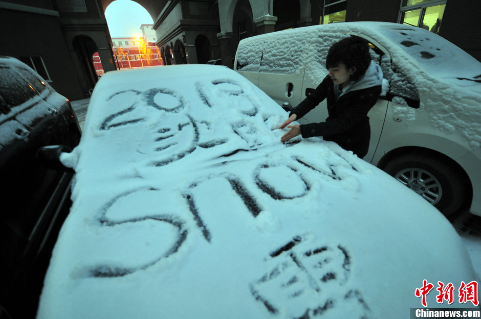 11月18日，行人在車輛的積雪上涂鴉。