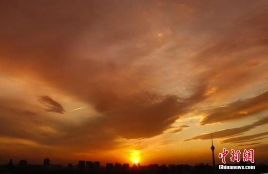 12月8日下午，強(qiáng)烈的西北風(fēng)光臨北京，吹散了籠罩全城上空的霧霾，冬日罕見的艷麗晚霞映紅了半邊天。
