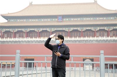11月1日，北京大部分地區(qū)重度污染，一名游客戴著口罩在午門(mén)前揮手跟朋友打招呼。 實(shí)習(xí)生 王飛 攝