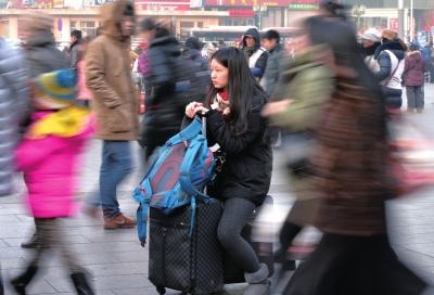 春運(yùn)首日，北京站客流量明顯增多，一名女孩在人流中等待進(jìn)站。