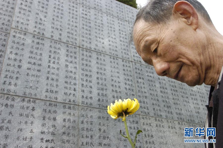 2006年4月5日，74歲的南京大屠殺幸存者佘子清手捧鮮花，祭奠被日軍殺害的母親。