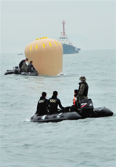 18日，搜救人員準備將氣囊捆綁到沉沒客輪上。