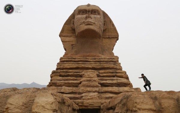 石家莊郊外，一名男子與山寨版獅身人面像合影留念。
