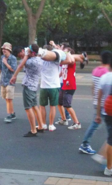 　四名外籍男子一同扛起醉漢拍照。