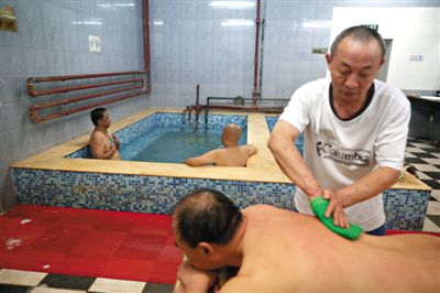 客人在搓澡。近日，百年歷史的鑫園浴池宣布將關(guān)張。新京報(bào)記者