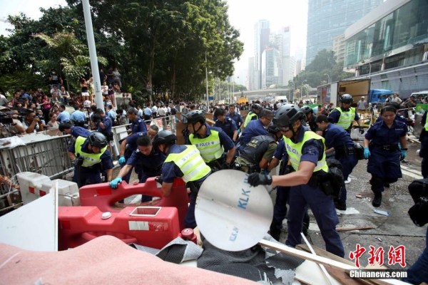 10月14日，警方清除金鐘道障礙物。大批警員在金鐘道現(xiàn)場(chǎng)清拆障礙物。部分警員戴上頭盔將障礙物移走。