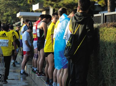 2013年10月20日，北京馬拉松比賽，由于廁位有限，一些選手在綠化帶“就地解決”。圖/IC