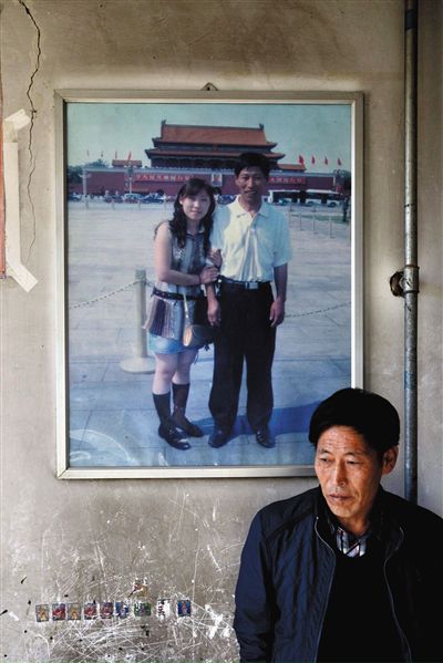 11月14日，承德市平泉縣，潘小梅父母的家，潘小梅父親靠在墻上，身后掛著數(shù)年前他和潘小梅在北京的合影照片。新京報記者