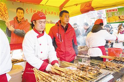 賣羊肉串?dāng)偽焕习遐w山（穿紅衣者）。新京報(bào)記者