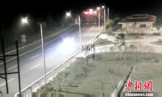 看到車輛經(jīng)過，孩子們便急忙跑到一旁的花圃上?！【焦﹫D　攝
