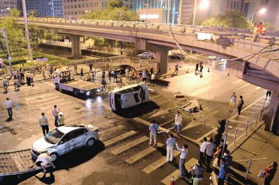 路虎沖下國貿(mào)橋砸中一輛起亞轎車，橋上厚達幾十厘米的水泥護欄被撞斷，碎石四處散落，數(shù)十群眾在現(xiàn)場圍觀。