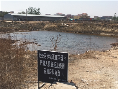 化肥廠滲坑的三分之一經(jīng)過(guò)治理，但水質(zhì)仍然呈黃褐色。