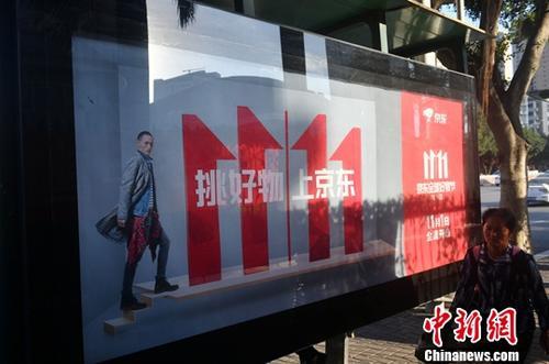 資料圖：11月1日，福州民眾從雙十一廣告牌前經(jīng)過(guò)。中新社記者 呂明 攝