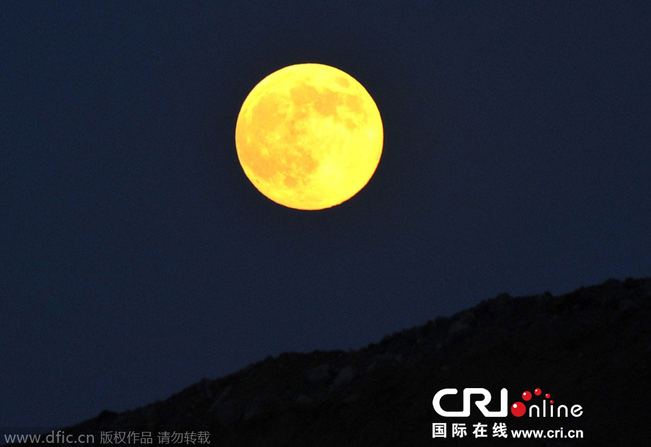 8月10日晚，一輪金燦燦的大月亮在遼寧省大連市東方升起。圖片來源：劉德斌/東方IC