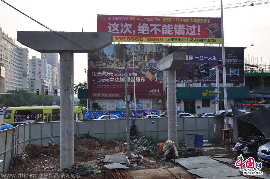 過(guò)街天橋一側(cè)的橋樁早已打好,可是對(duì)面的郵政銀行網(wǎng)點(diǎn)依舊在照常營(yíng)業(yè)。