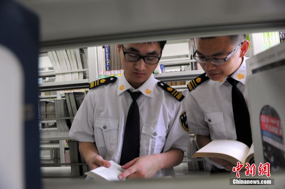 5月8日，武漢輕工大學(xué)圖書館保安吳濤與江力在圖書館交流學(xué)習(xí)。