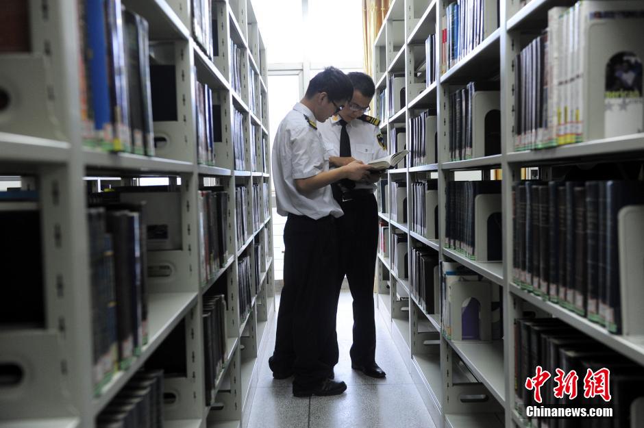 5月8日，武漢輕工大學(xué)保安吳濤與江力在圖書館交流學(xué)習(xí)。中新社發(fā) 張暢 攝