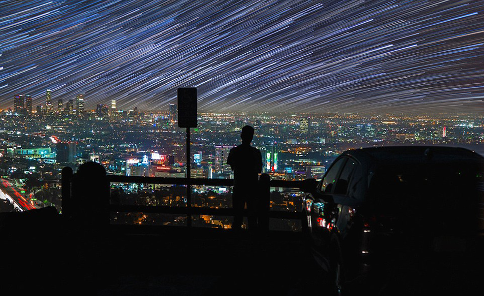 照片中，一名男子看著流星和隕星劃過天空。（網(wǎng)頁截圖）